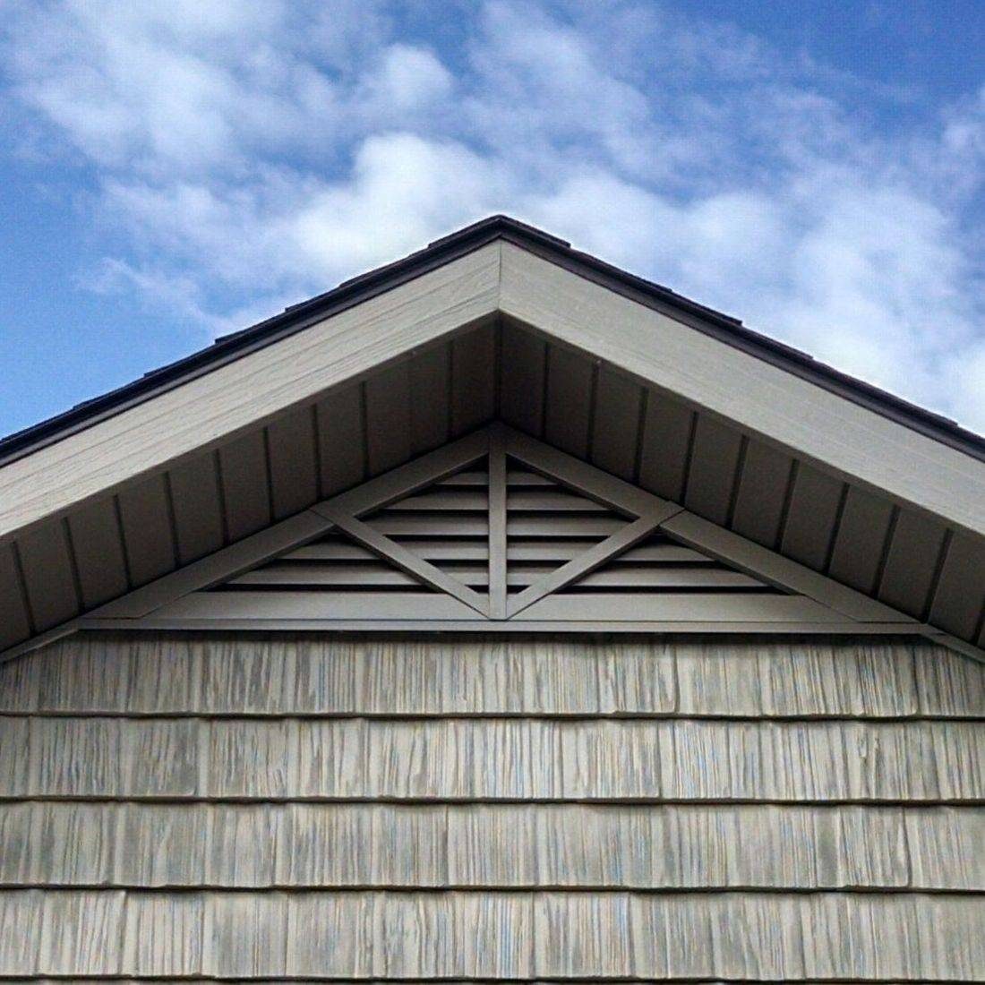 Close-up view of a metal gable vent being installed on a roof gable