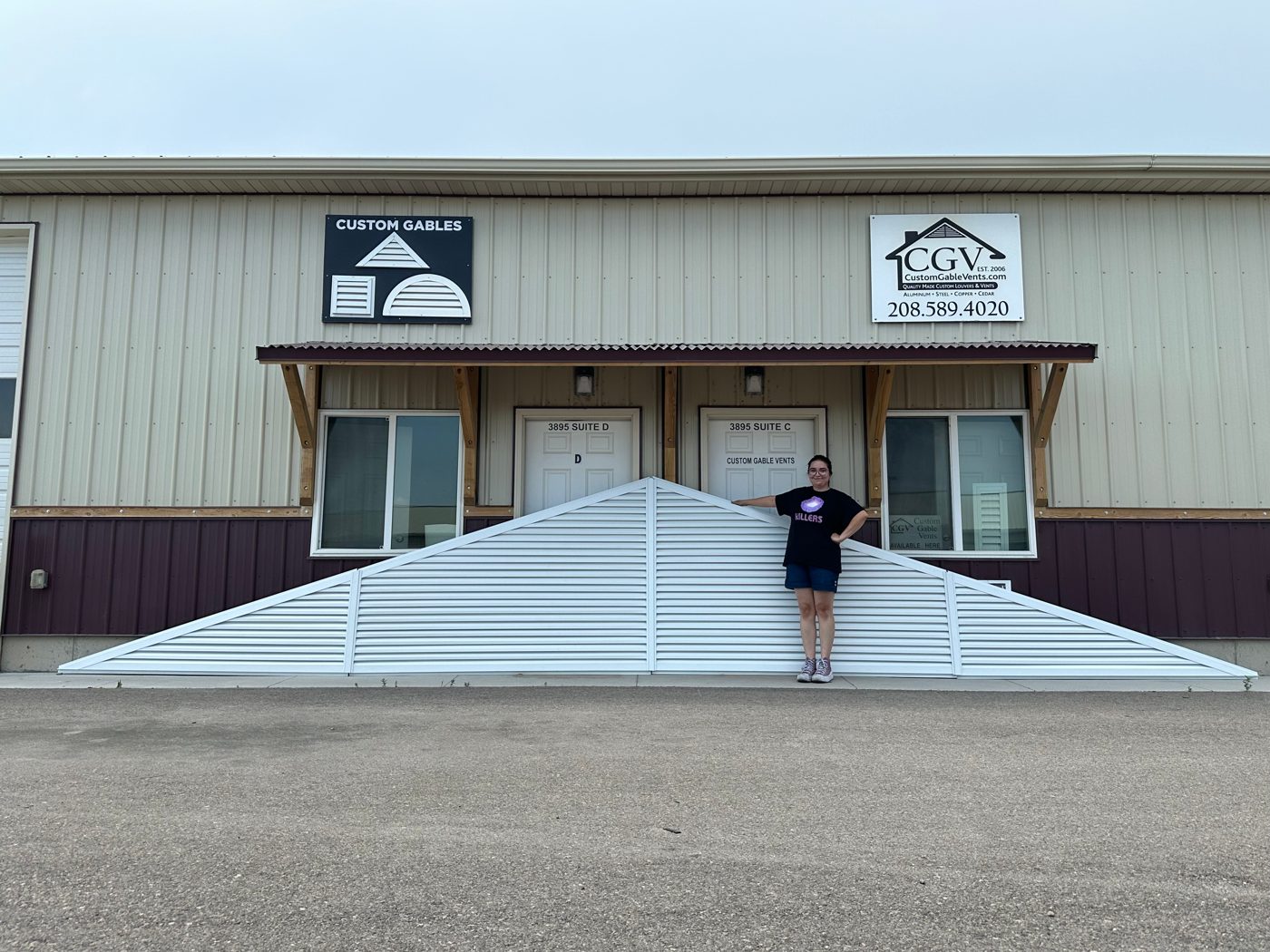 Large four-piece triangle gable vent in front of the Custom Gable Vents shop, with a person for scale